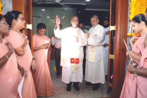 Clergy and sisters gathered in a hostel doorway for the blessing ceremony