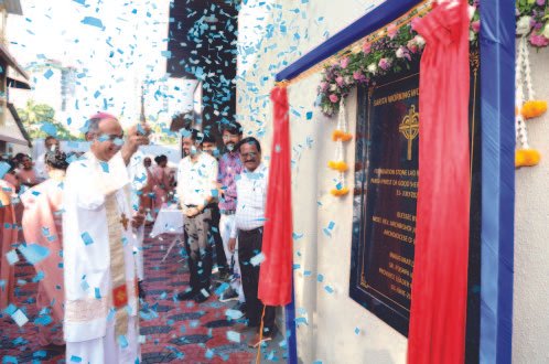 Guests gathered beside the decorated inauguration plaque at Sarita hostel