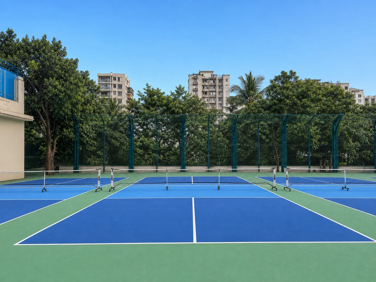 Clean blue recreation courts with trees and city buildings beyond